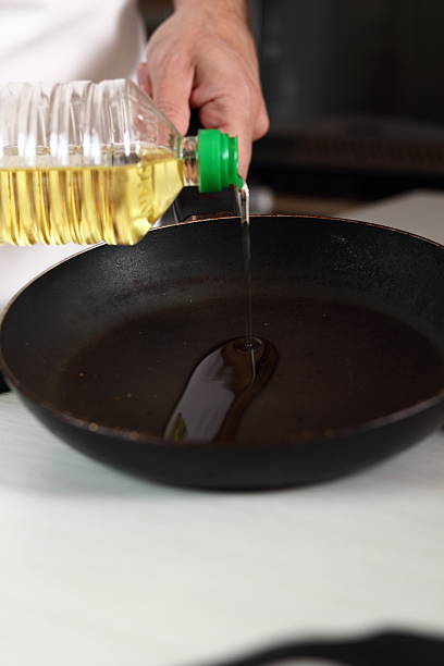 istock Pouring vegetable oil into frying pan 636603168