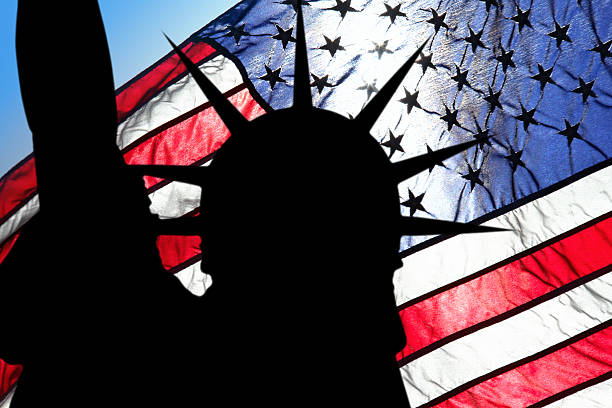 istock statue of liberty and american flag 636613726