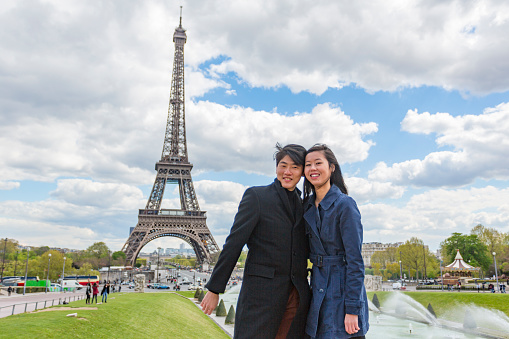 Romantic young Asian couple in love while on the trip of a lifetime vacation in Paris