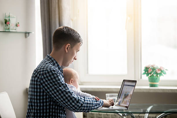 istock Man and a baby at the laptop 636616712