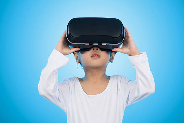 istock Asian Chinese little girl experiencing virtual reality eyeglasss 636618142