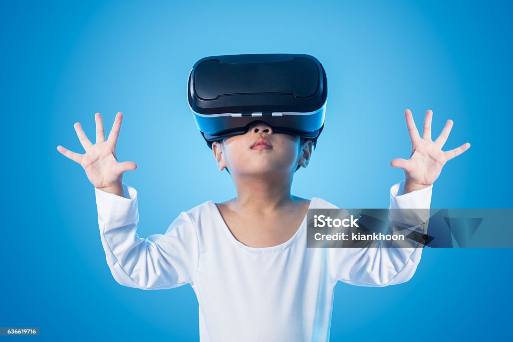 Asian Chinese little girl experiencing virtual reality eyeglasss Asian Chinese little girl experiencing virtual reality eyeglassses in isolated background. Virtual Reality Simulator Stock Photo
