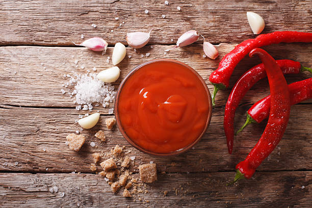 Red chilli sauce Sriracha with ingredients. horizontal top view stock photo
