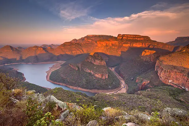 View over the Blyde River Canyon and the Three Rondavels in South Africa at sunset.
