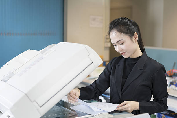 istock asian woman secretary using copy machine in the office 636630990