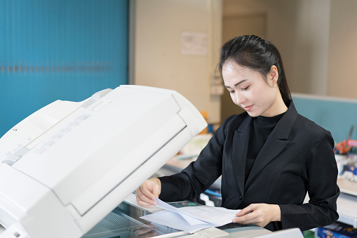 asian woman secretary using copy machine in the office