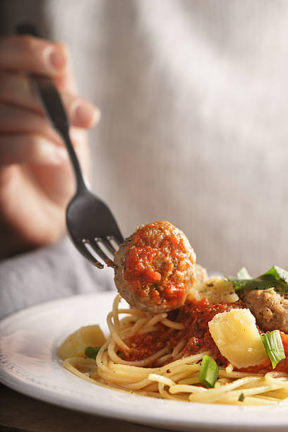 Woman eating spaghetti with meatballs stock photo
