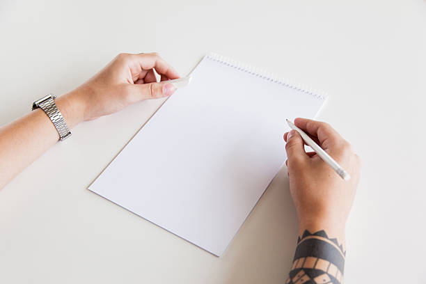 istock Man's Hand with a tattoo holding pencil and eraser 636635650