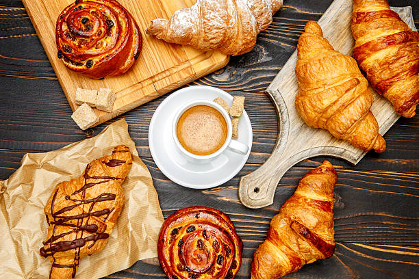 istock cup of coffe and croissant on wooden background 636636720