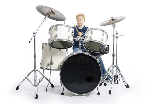 istock young caucasian boy at drum kit in studio plays music 636637686