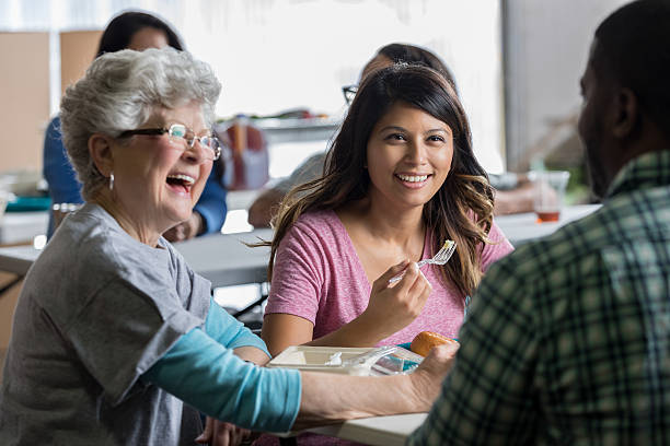 istock Diverse group of people enjoy meal in soup kitchen 636644278