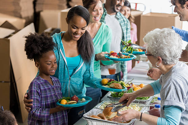 istock Friendly volunteer serves family meal in soup kitchen 636644360