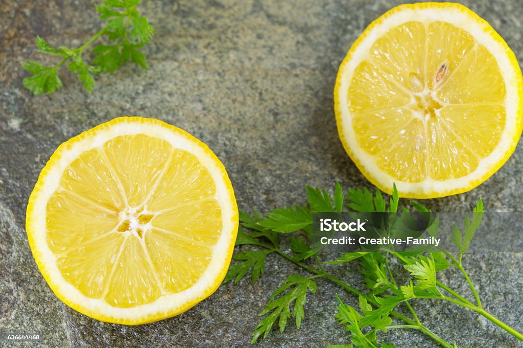 Lemon and parsley Raw lemon and parsley on stone table Lemon - Fruit Stock Photo