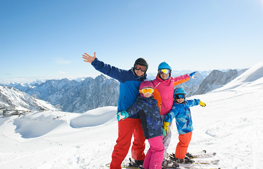Family skiing and snowboarding in mountains