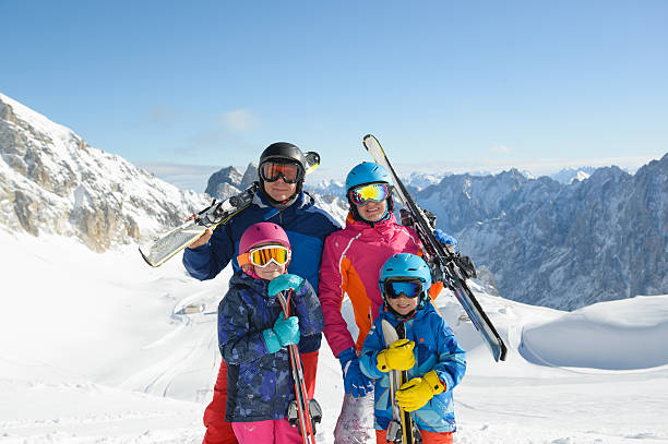 istock Happy family enjoying winter vacations in mountains . 636645936