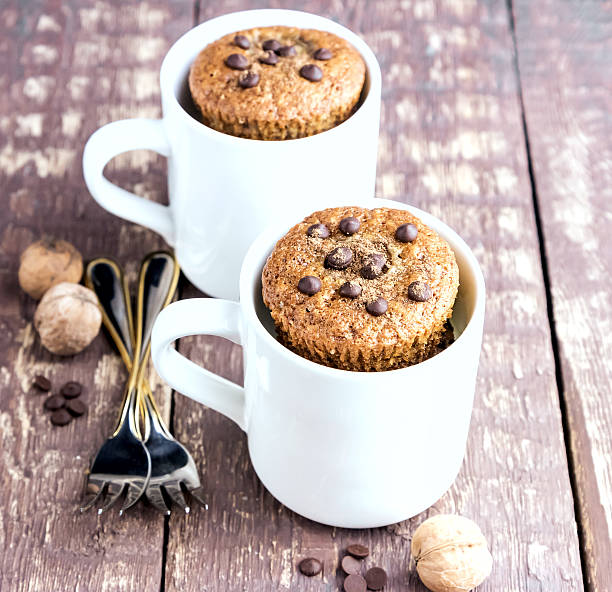 istock Chocolate muffins with chocolate drops served in white mugs 636646450