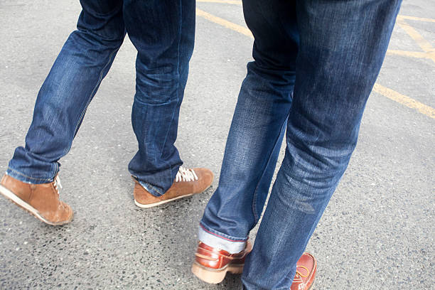 istock Two young men wearing jeans walking on asphalt. 636648184