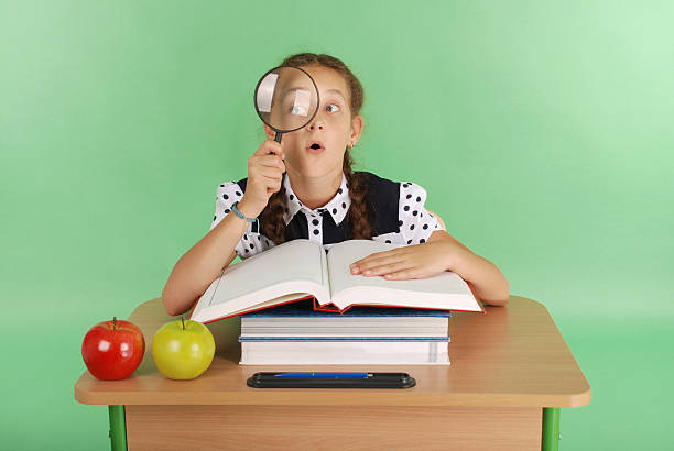 istock Girl in a school uniform sitting at a desk 636649626