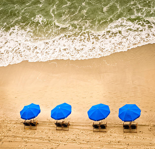 Sedie a sdraio, ombrelloni e onde dell'oceano - foto stock