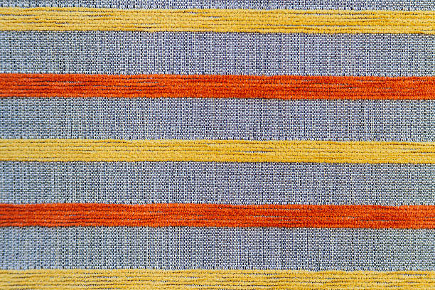 istock Gray fabric texture embroidered with orange and yellow stripes 636652760