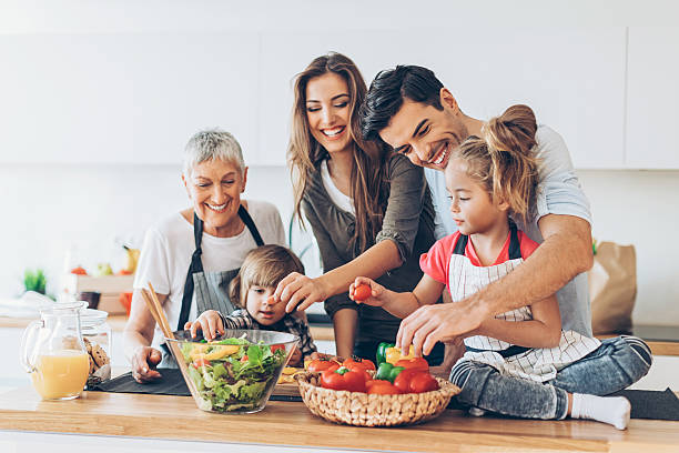 Multi-generation family cooking Three-generation family with two small children preparing food. pepper vegetable photos stock pictures, royalty-free photos & images