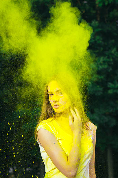 istock Beautiful young model covered yellow dry powder holi 636653742