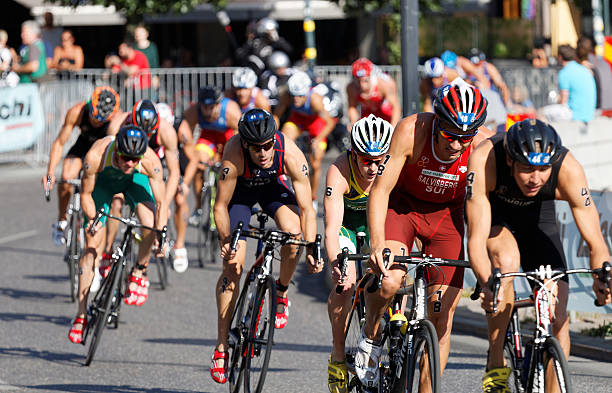 grand groupe de cyclistes triathlon contre les concurrents - triathlon cycling bicycle competition photos et images de collection