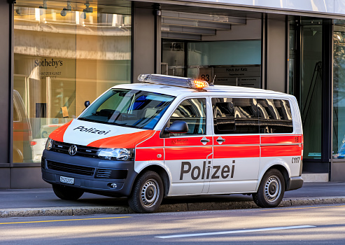 Zurich, Switzerland - 27 December, 2016: a Zurich Municipal Police van parked with flashing lights on Tahlstrasse street, a window of the Sotheby's office in the background. Zurich Municipal Police is the third largest police corps in Switzerland, after Zurich and Bern Cantonal Police corpses.