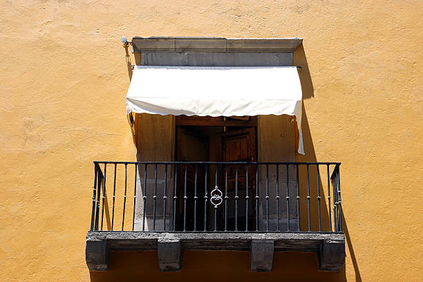 Colonial balcony. View on a typical urban scene with closed French window, Mexico