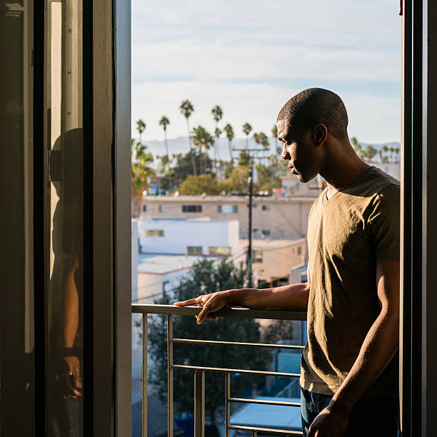 istock Young black man standing on open balcony, Santa Monica, California 636658214