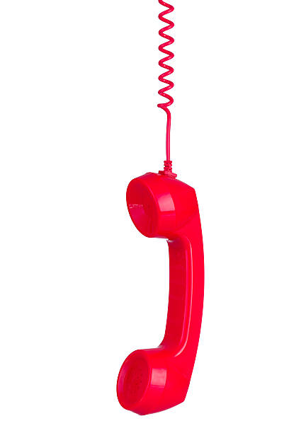 istock Red phone headset hanging by its wire isolated 636660418
