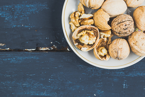 Walnuts and shells on dark blue wooden background