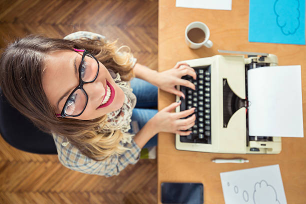 young writer using typing machine - author writing retro revival women imagens e fotografias de stock