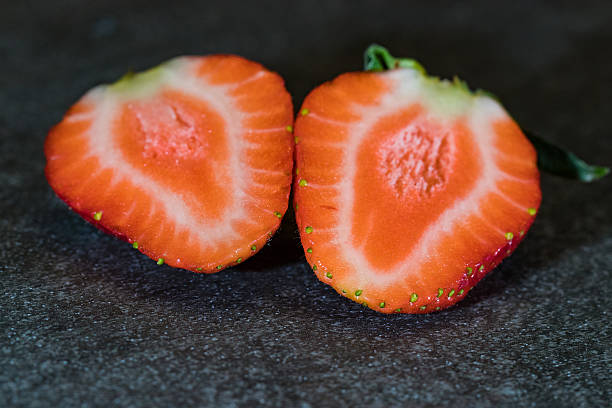 istock Single sliced strawberry on gray stone 636670096