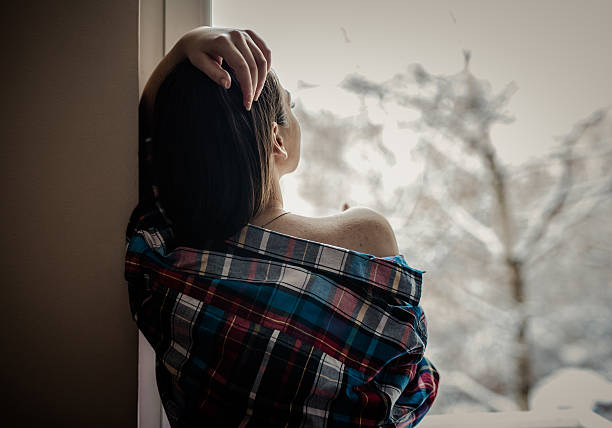 istock Girl looking through the window 636670750