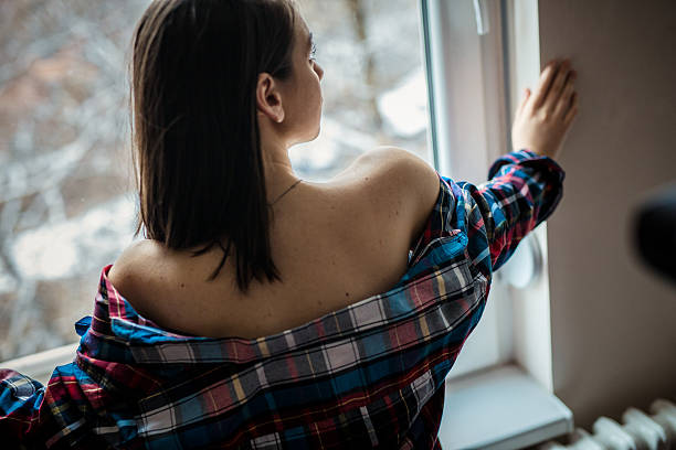 istock Girl looking through the window 636671078