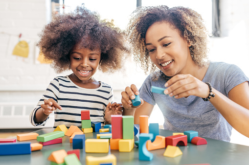 Boy assembling house from pieces of magnetic construction set.