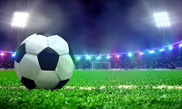 istock Soccer ball in a stadium field with bright spotlights 636675430