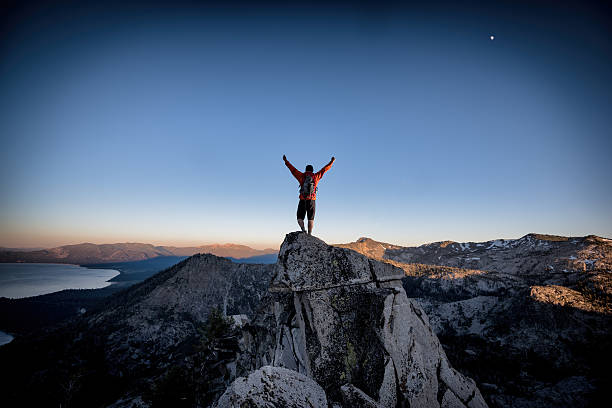 Success and Victory in the mountains A climber reaches the summit of an exposed mountain top in the Tahoe backcountry, California mountaineering stock pictures, royalty-free photos & images