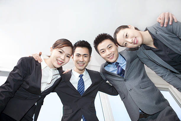istock Business colleagues standing in huddle, arm around,low angle view 636677088