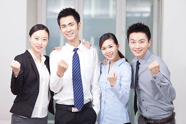 istock Group of young business people cheering 636678960
