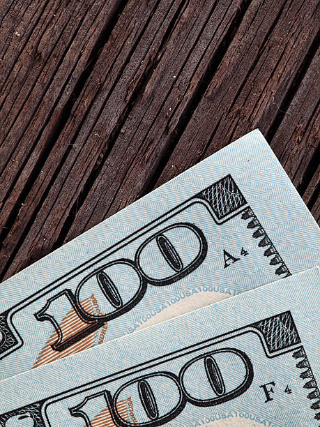 istock The 100 dollar bills on a wooden background 636679272