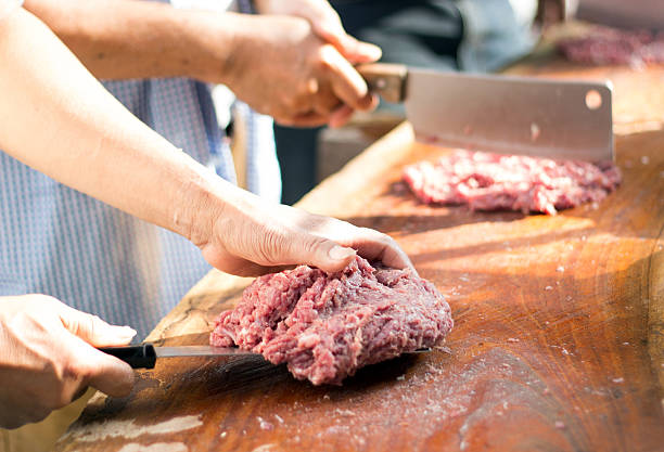 istock hand hold knife chopping pork on hard wood 636679794