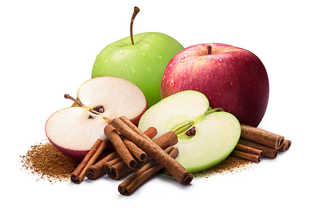 Red and green apples with cinnamon, paths Whole and halved red and green apples next to piles of cinnamon, in sticks and ground. Clipping paths, shadow separated green apple slice stock pictures, royalty-free photos & images