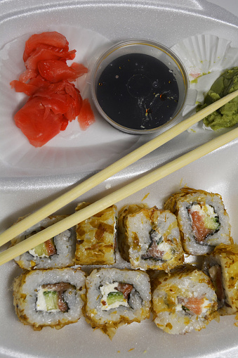 sushi rolls with sauce and wasabi and chopsticks