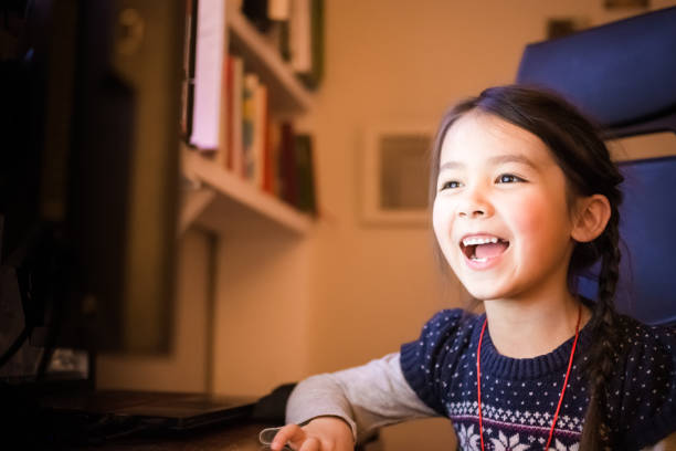 istock Happy little girl using a computer at home 636692044