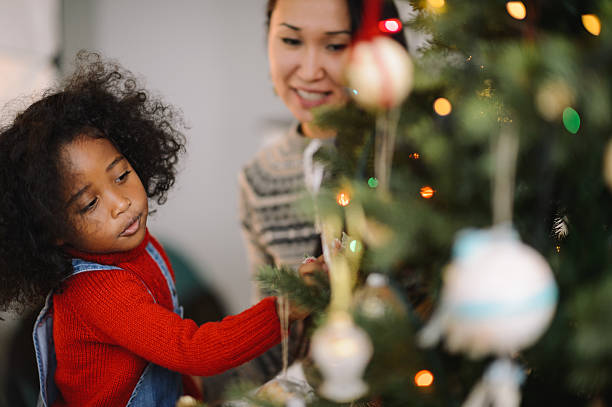 istock Mother and daughter decorating Christmas tree 636693836