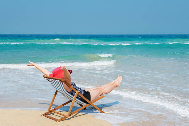 istock Happy woman  in red sunhat on the beach 636694330