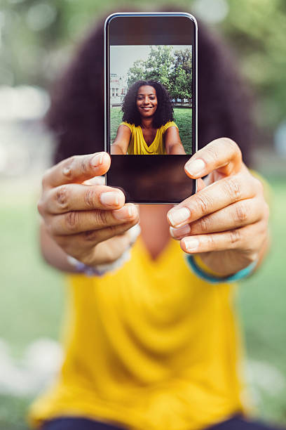 Showing selfie to the camera Portrait of beautiful mixed-race woman taking selfie selfie photos stock pictures, royalty-free photos & images