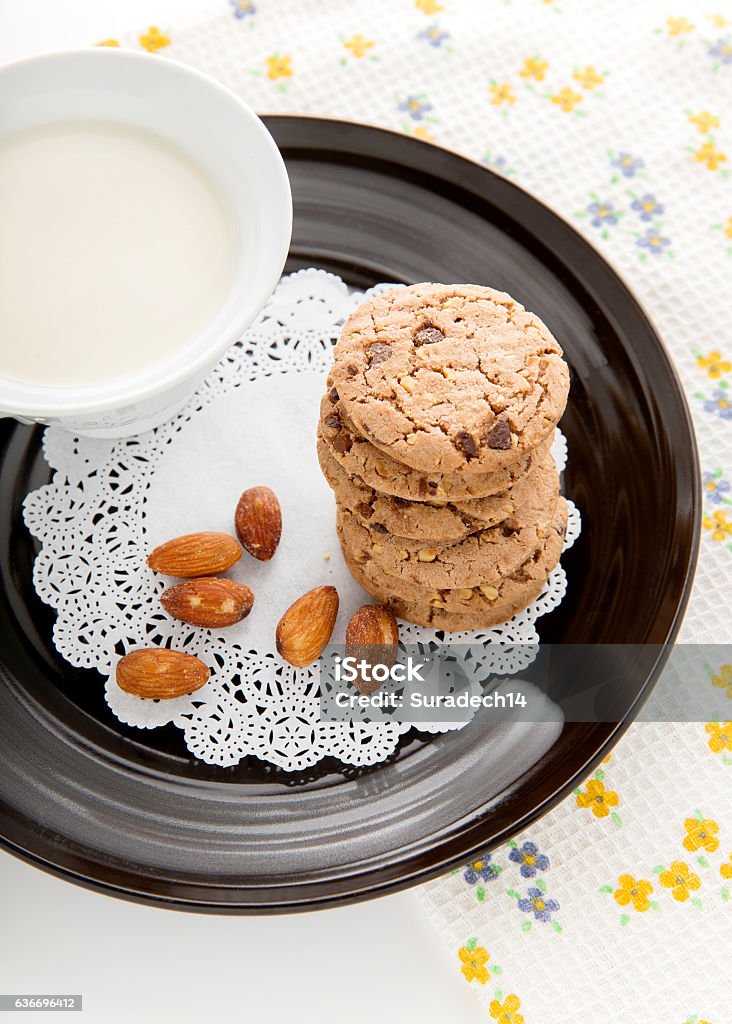 Chocolate chip cookies with milk in cup Chocolate chip cookies with milk in cup on black dish Baked Stock Photo